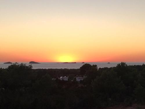 a sunset over the ocean with the sun setting in the sky at Fiframar in Sant Josep de Sa Talaia