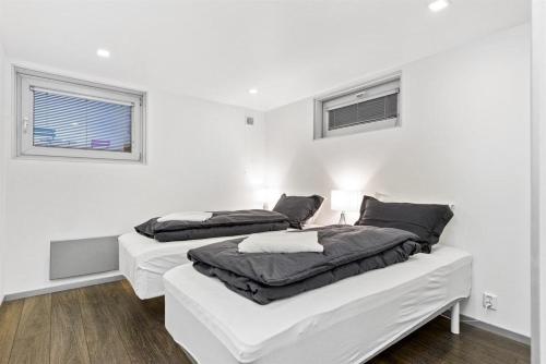 two beds in a room with white walls at Peak Apartments in Vossevangen