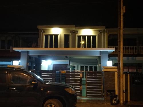 a car parked in front of a building at night at EJ Guesthouse in Cukai