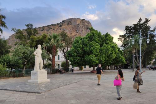 a group of people walking in front of a statue at apt.27-103 in Nafplio