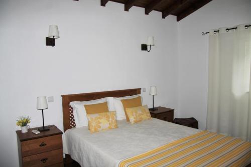マルヴァオンにあるQuinta da Figueirinhaのベッドルーム1室(大型ベッド1台、ナイトスタンド2台付)