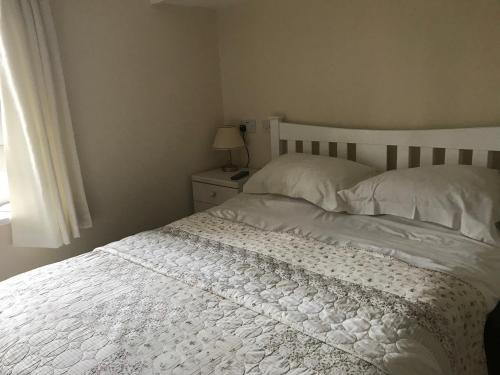1 dormitorio con 1 cama con sábanas blancas y ventana en Garstoncottage en Bath