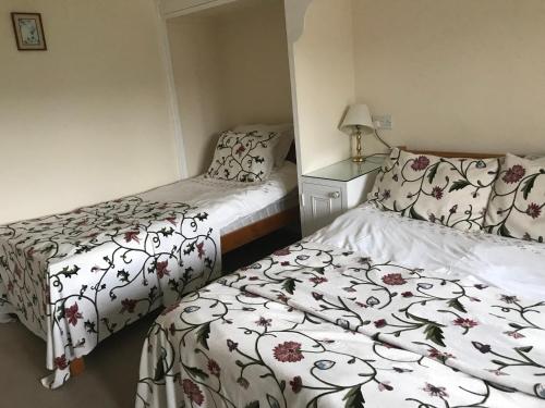 2 camas en una habitación pequeña con faldas en Garstoncottage en Bath