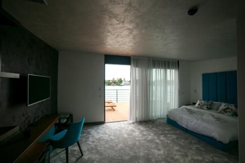 a bedroom with a bed and a desk and a window at FLOW in Belgrade