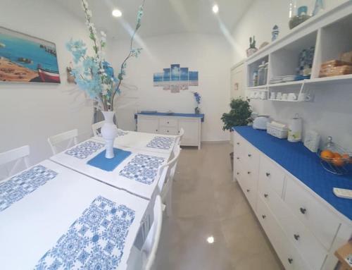 a kitchen with white cabinets and blue counters at I Tesori del Mare in Letojanni