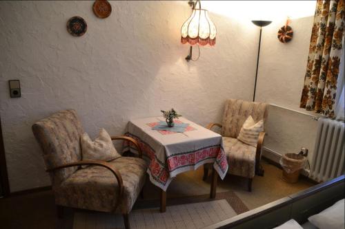 a room with a table and two chairs and a lamp at Adieu Alltag: Pension Oesterle im Schwarzwald in Schönmünzach