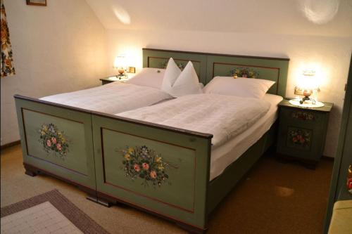 a bedroom with a large bed with white sheets and pillows at Adieu Alltag: Pension Oesterle im Schwarzwald in Schönmünzach