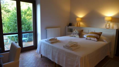 a bedroom with a white bed with pillows and a window at Chiosi Country Club in Corleone