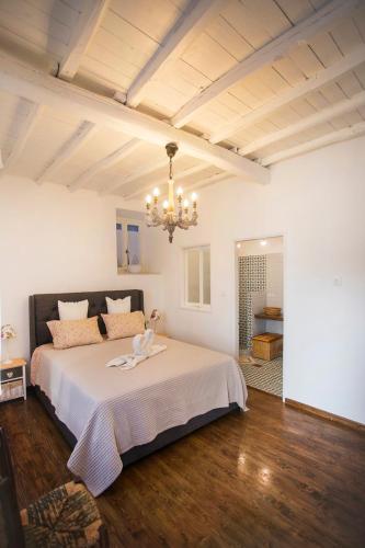 a bedroom with a large bed and a chandelier at Rodia House in Glossa