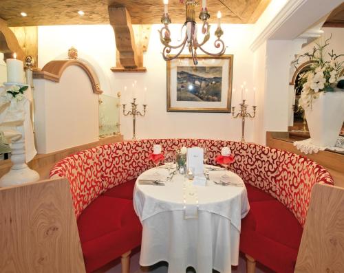 a restaurant with a red couch and a table at Hotel Neue Post in Hippach