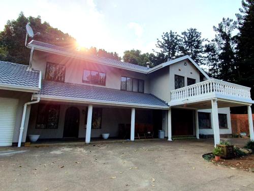a white house with a porch and a balcony at Dream Hills in Hillcrest