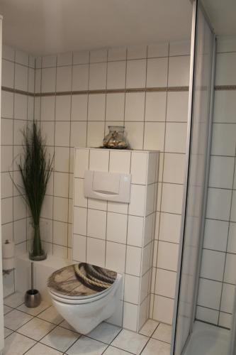 a bathroom with a toilet with a wooden seat at Lutzi´s Ferienwohnung in Rostock