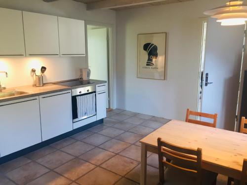 a kitchen with white cabinets and a wooden table at Happy Hill Farm in Gilleleje