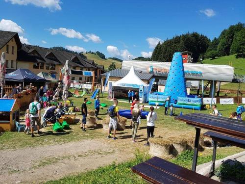 a group of people standing in a field with a play park at Apartmán Plesnivec in Donovaly