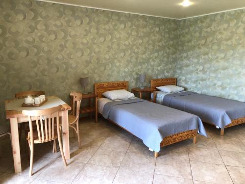 Cette chambre comprend 2 lits, une table et une table. dans l'établissement Dzeņi, à Amatciems