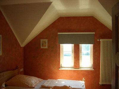 a bedroom with a bed and a window at Hotel Zug um Zug in Schemmerhofen