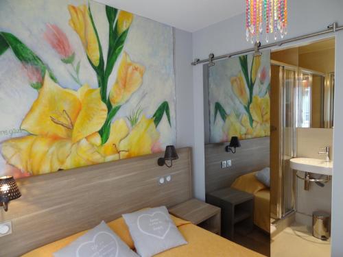un baño con una pintura de flores en la pared en Amélie Hotel, en París