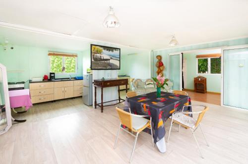 a kitchen and dining room with a table and chairs at Rusty Pelican - Lazy Lizard Container Home. in La Gaulette