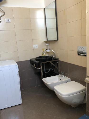 a bathroom with a toilet and a sink at Rainbow Holiday Apartments in Vlorë