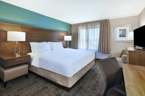 a hotel room with a large bed and a television at Staybridge Suites Columbia-Highway 63 & I-70 by IHG in Columbia