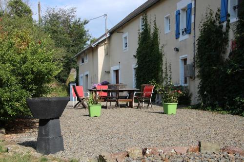 a patio with a table and chairs in a yard at La Parisiere in Gavray
