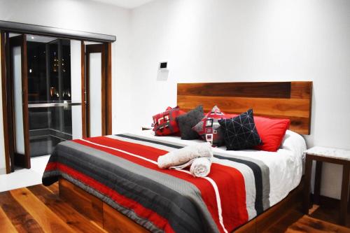 1 dormitorio con 1 cama grande con almohadas rojas y negras en En el Centro Penthouse Lujo AC WiFi 300mbps, en Aguascalientes