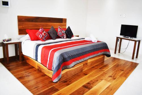 a bedroom with a bed with red and black pillows at En el Centro Penthouse Lujo AC WiFi 300mbps in Aguascalientes