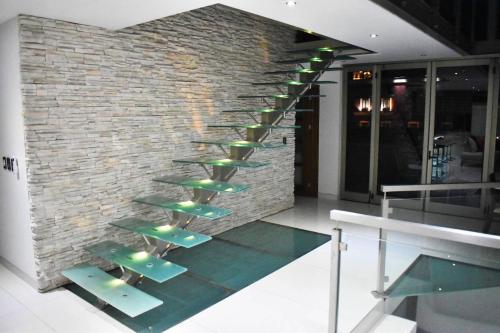 a brick wall with a staircase with green seats at En el Centro Penthouse Lujo AC WiFi 300mbps in Aguascalientes