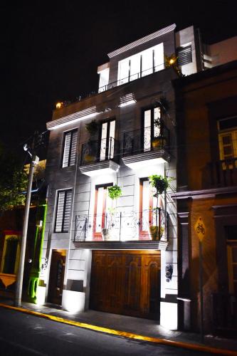 a lit up building with windows and doors at night at En el Centro Penthouse Lujo AC WiFi 300mbps in Aguascalientes