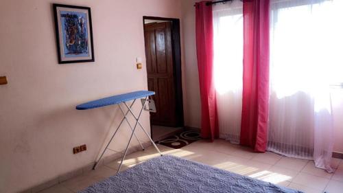 Zimmer mit einem blauen Tisch in einem Zimmer in der Unterkunft Djembé Appart Fidjrosse in Segbana
