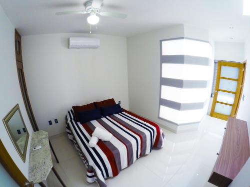 a bedroom with a bed with a striped blanket at En el Centro Penthouse Lujo AC WiFi 300mbps in Aguascalientes