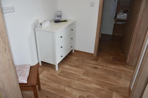 a room with a white dresser and a wooden floor at Vinný sklep U Ševčíků in Mutěnice