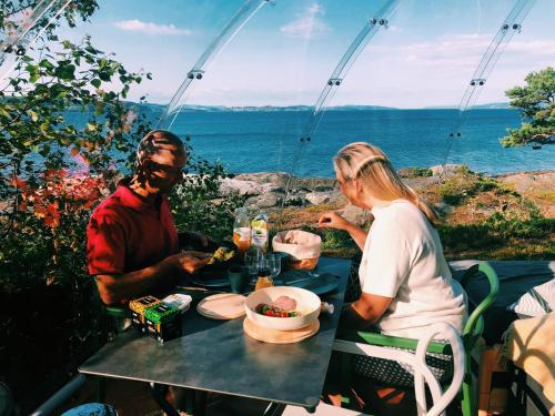 a man and a woman sitting at a table eating food at Trones Eye in Verdal