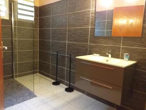 un baño con lavabo y ducha en Villa Bouillante, en Bouillante