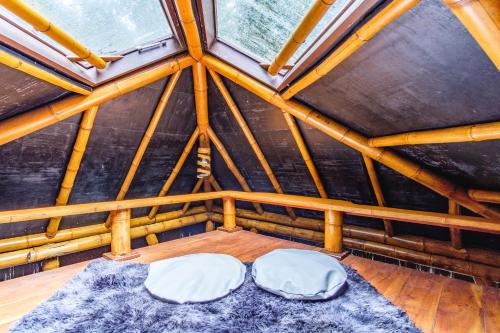 two beds in a room in a wooden roof at Universo Pol Bamboo Hostel in Morro de São Paulo