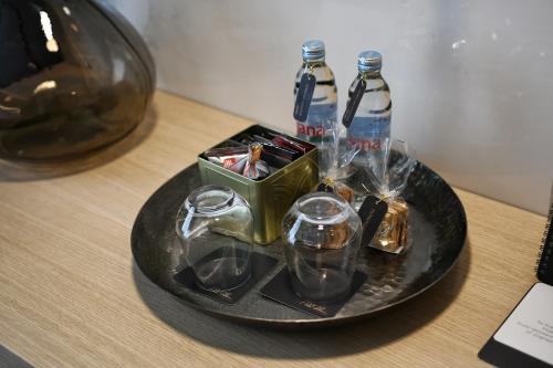 a black plate with glasses and bottles on a table at Pod Zidom Rooms in Zagreb