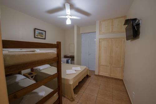 a bedroom with bunk beds and a ceiling fan at Hotel Alto da Boa Vista in Analândia