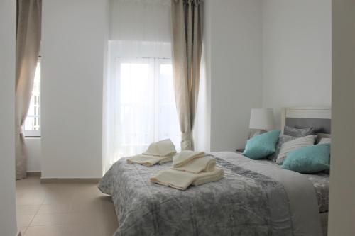 um quarto com uma cama com toalhas em Apart Baía do Sado II em Setúbal