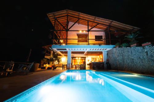 a swimming pool in front of a house at night at Finca Boutique el Diamante in Salgar