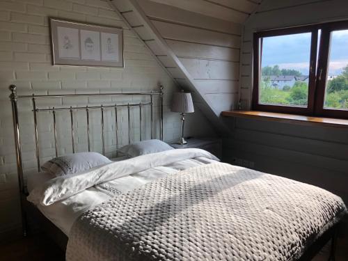 Un dormitorio con una cama grande con ventana. en Dom wakacyjny z basenem, en Dębki