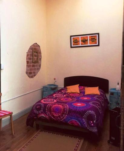 a bedroom with a bed with a purple blanket at El Secreto Casa Art in Montevideo