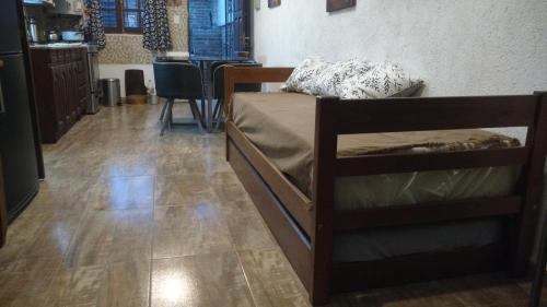 Un dormitorio con una cama y suelo de madera. en Casa de descanso "El Jagüel", en San Marcos Sierras