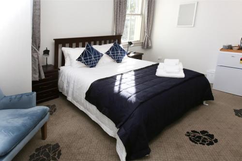 a bedroom with a large bed with blue pillows at The Prospect of Howick Accommodation in Auckland
