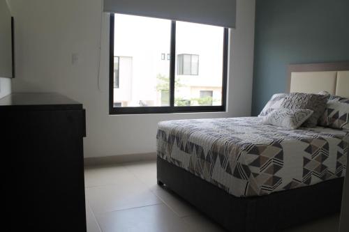 a bedroom with a bed and a large window at Suits Murato in San Luis Potosí