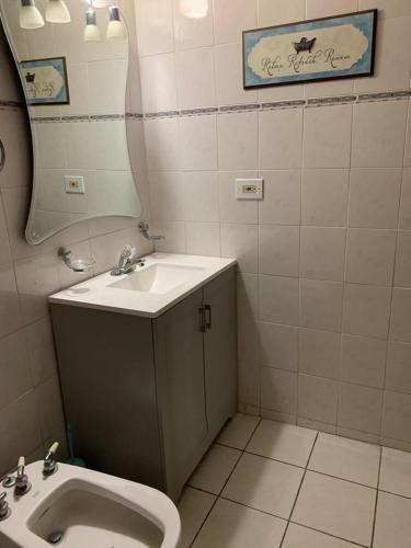 a bathroom with a sink and a toilet and a mirror at Los Pinos House in Yauco