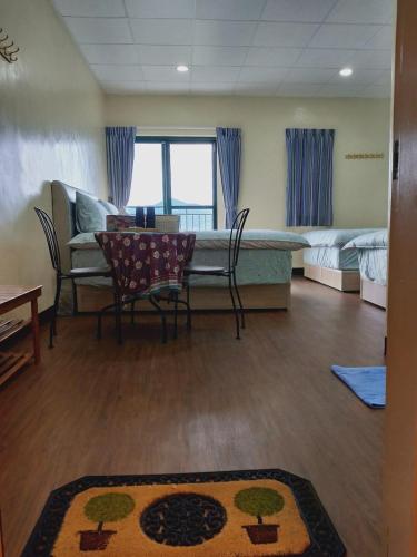 a living room with a table and chairs and a bed at 崗好山莊 in Jianshi