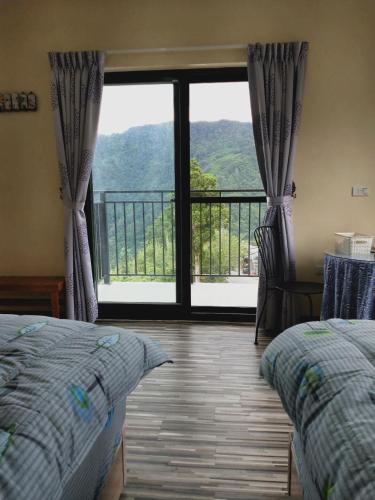 a bedroom with a large window with a view of a mountain at 崗好山莊 in Jianshi
