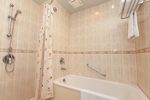 W łazience znajduje się biała wanna i prysznic. w obiekcie Hoya Hotel w mieście Wenquan