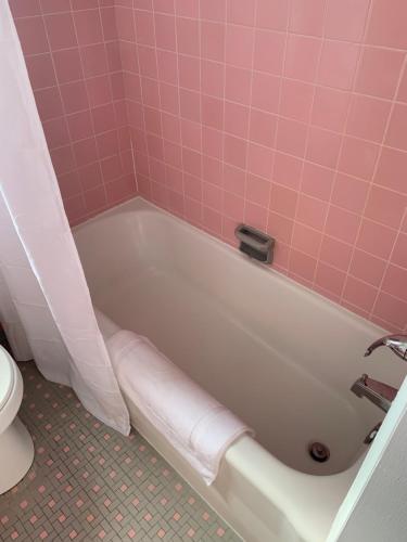 a pink bathroom with a tub and a toilet at Cape Motel in Cape Charles