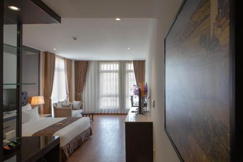 a hotel room with a bed and a living room at Dai Viet Hotel in Thanh Hóa
